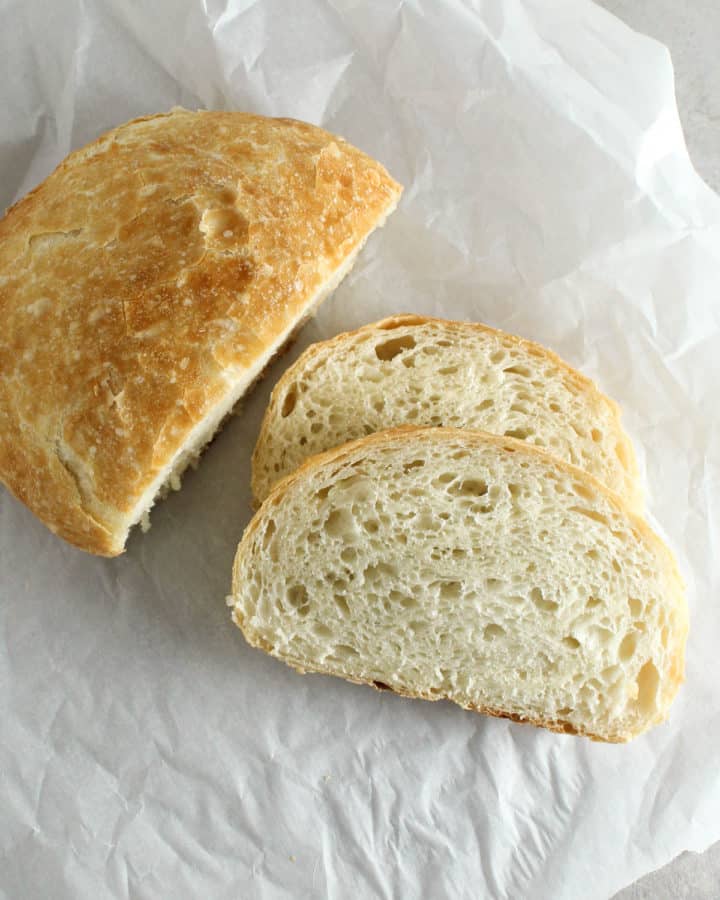 half sliced loaf of bread on a piece of parchment paper
