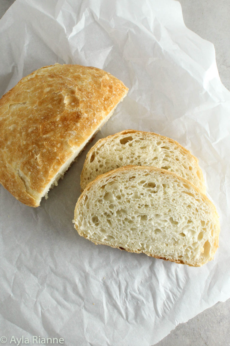 half sliced loaf of bread on a piece of parchment paper
