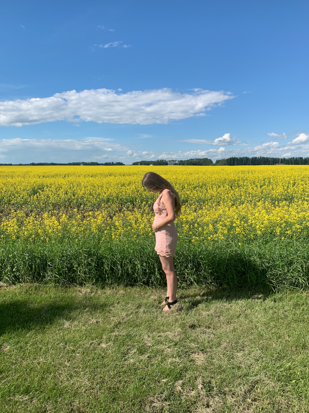 First Trimester photo standing in a field of flowers
