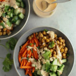 One full yum yum bowl with carrots, cucumbers, chickpeas and yum yum sauce. One partial yum yum bowl and one cup of yum yum sauce.