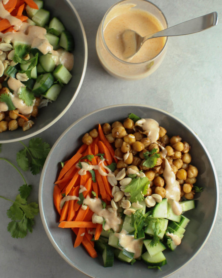 One full yum yum bowl with carrots, cucumbers, chickpeas and yum yum sauce. One partial yum yum bowl and one cup of yum yum sauce.