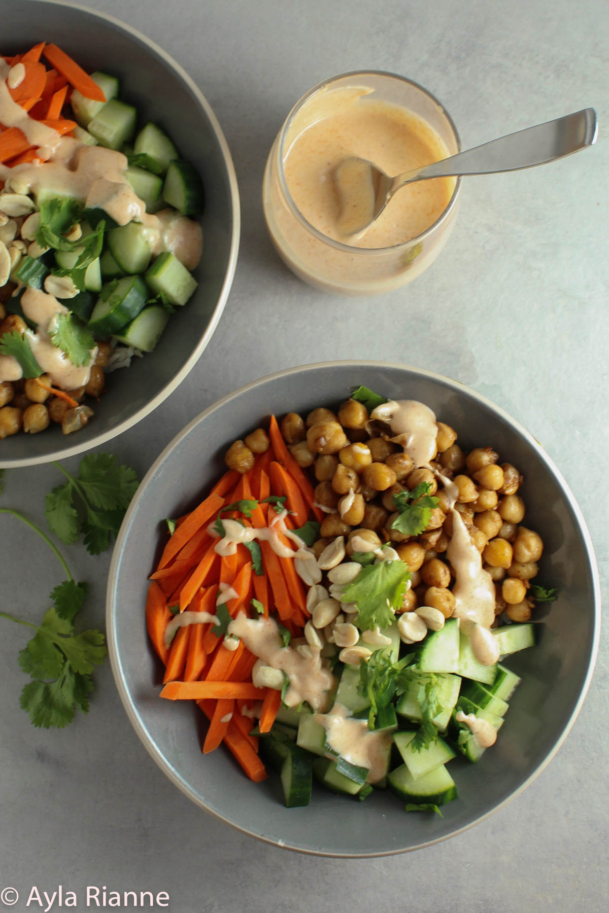 One full yum yum bowl with carrots, cucumbers, chickpeas and yum yum sauce. One partial yum yum bowl and one cup of yum yum sauce.
