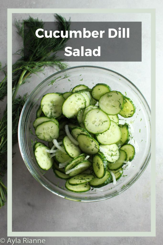 cucumber dill salad in a glass bowl with fresh dill behind it with a border around the edge and cucumber dill salad text over it