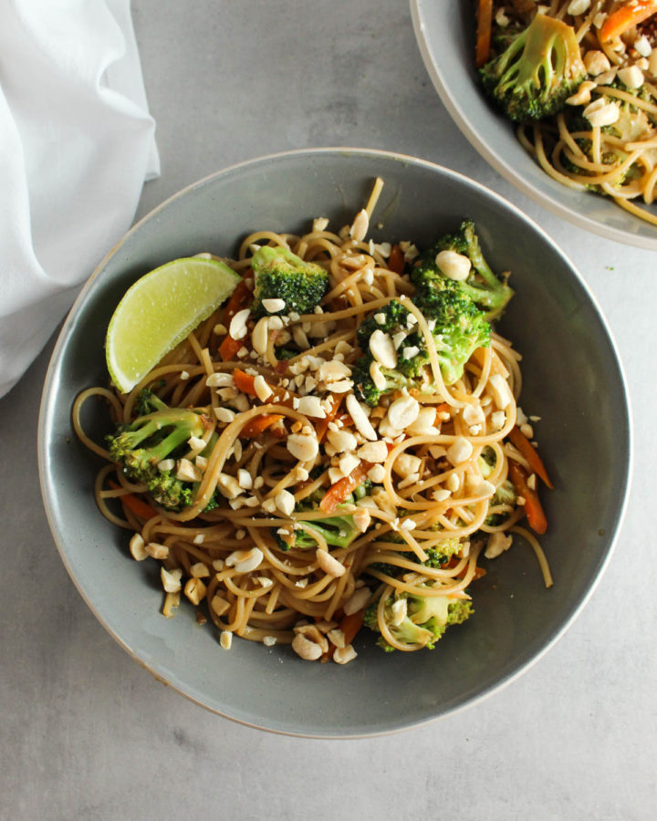 a bowl of peanut noodles with a second bowl in the background