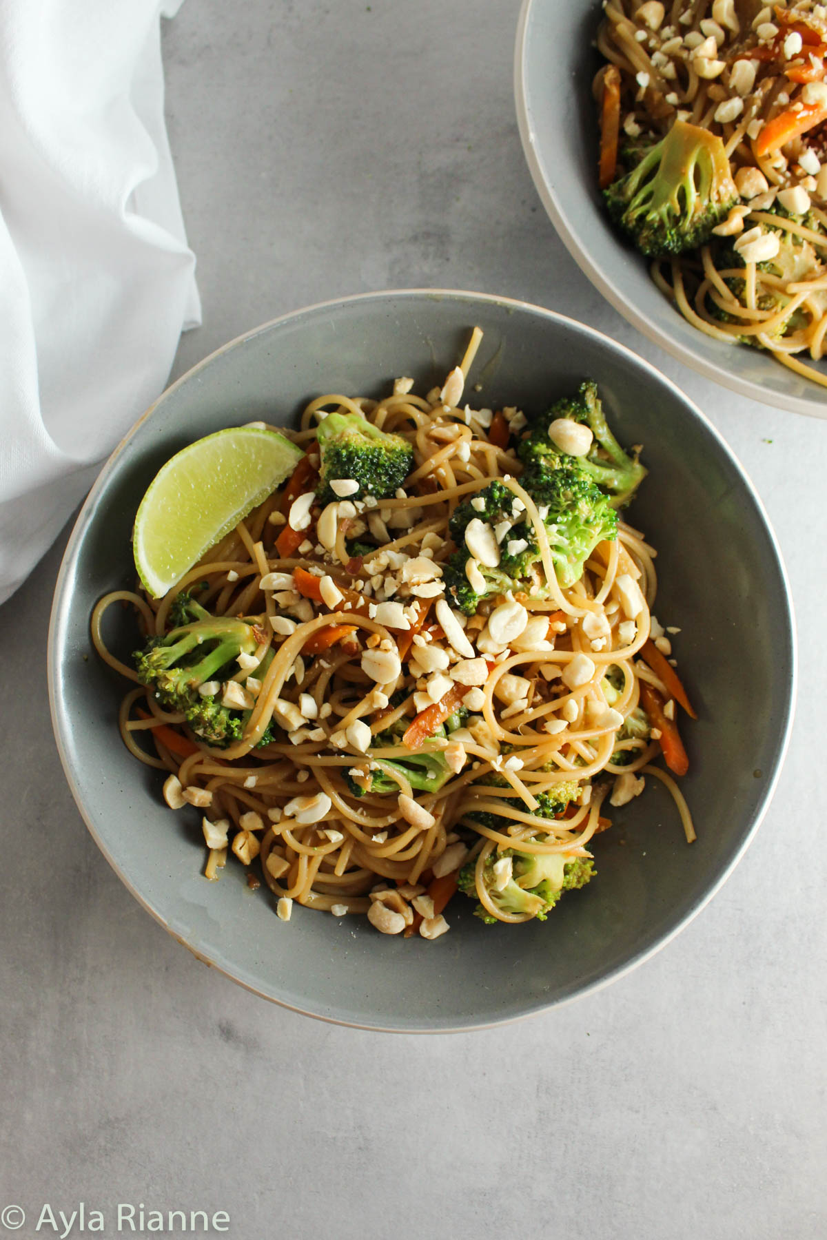 a bowl of peanut noodles with a second bowl in the background