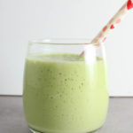 green smoothie in a glass with a straw