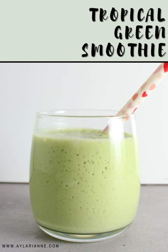 tropical green smoothie in a glass with a straw and text