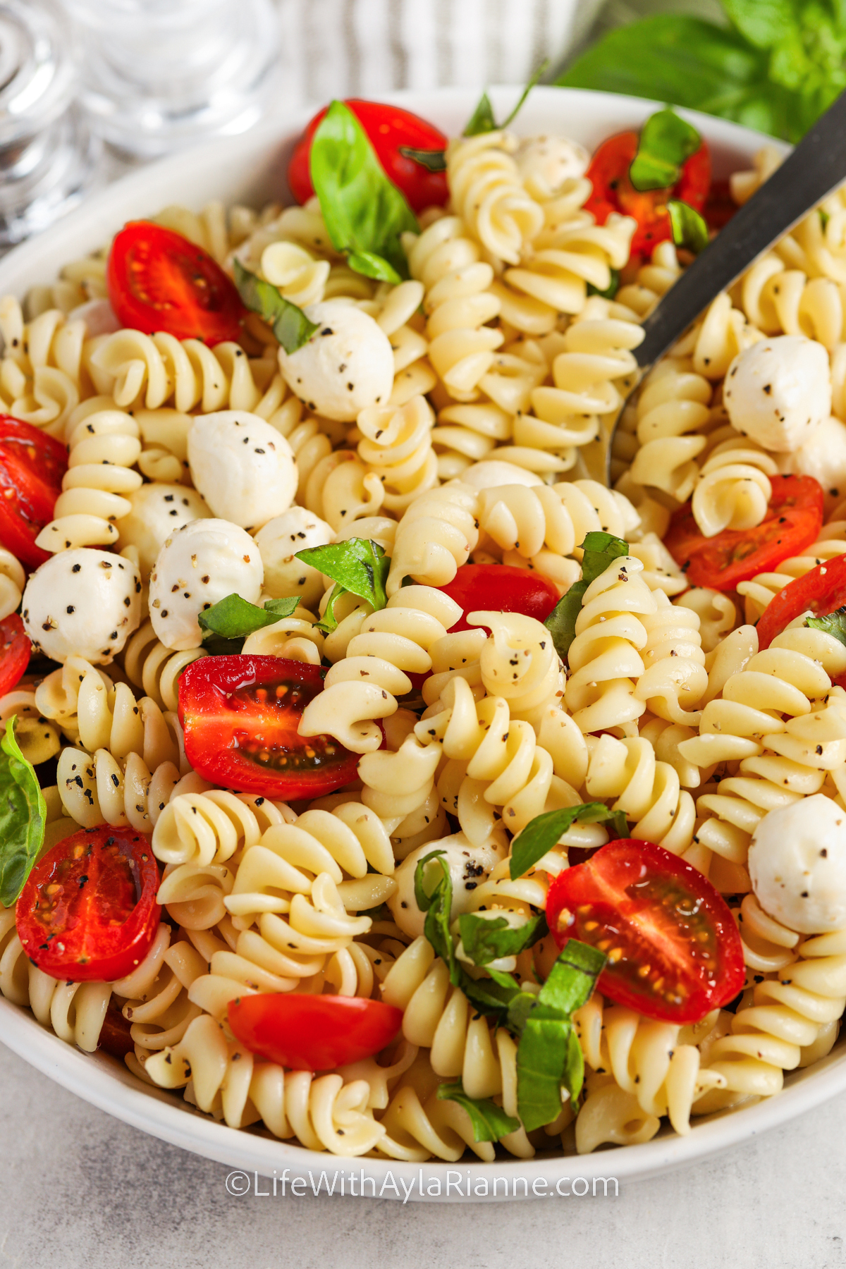 Caprese Pasta Salad in a bowl with a fork