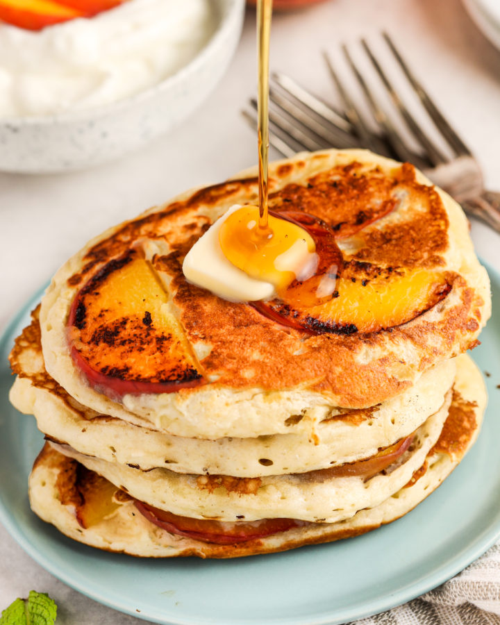 pouring syrup over Peach Pancakes