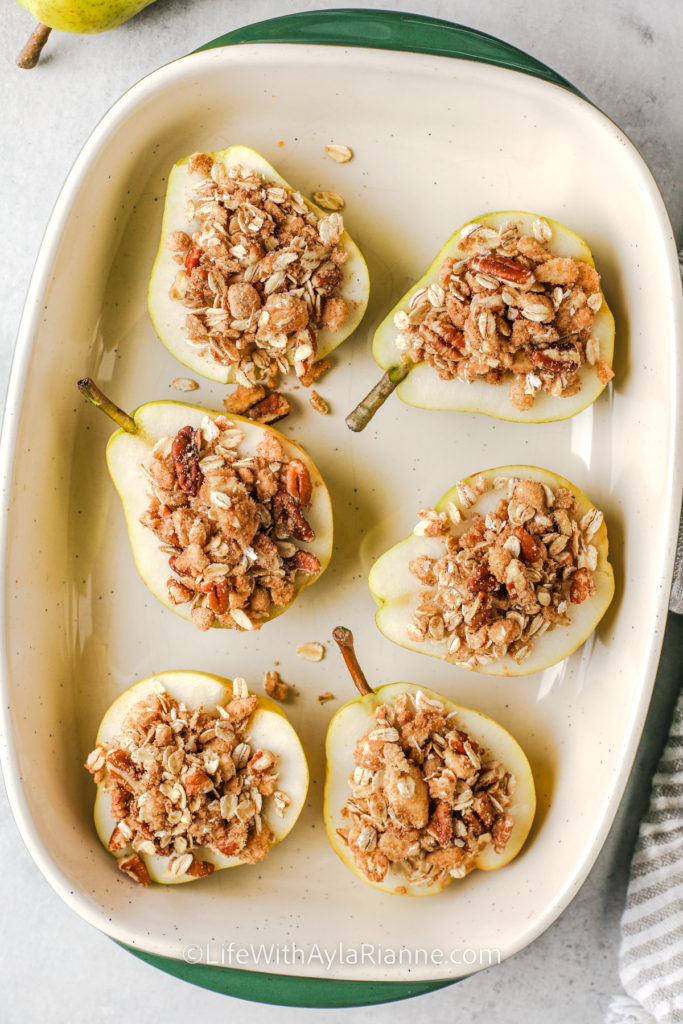 Pears in a baking dish topped with crumble mixture to make baked pears