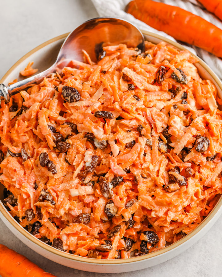 simple Carrot and Raisin Salad in a bowl with a spoon