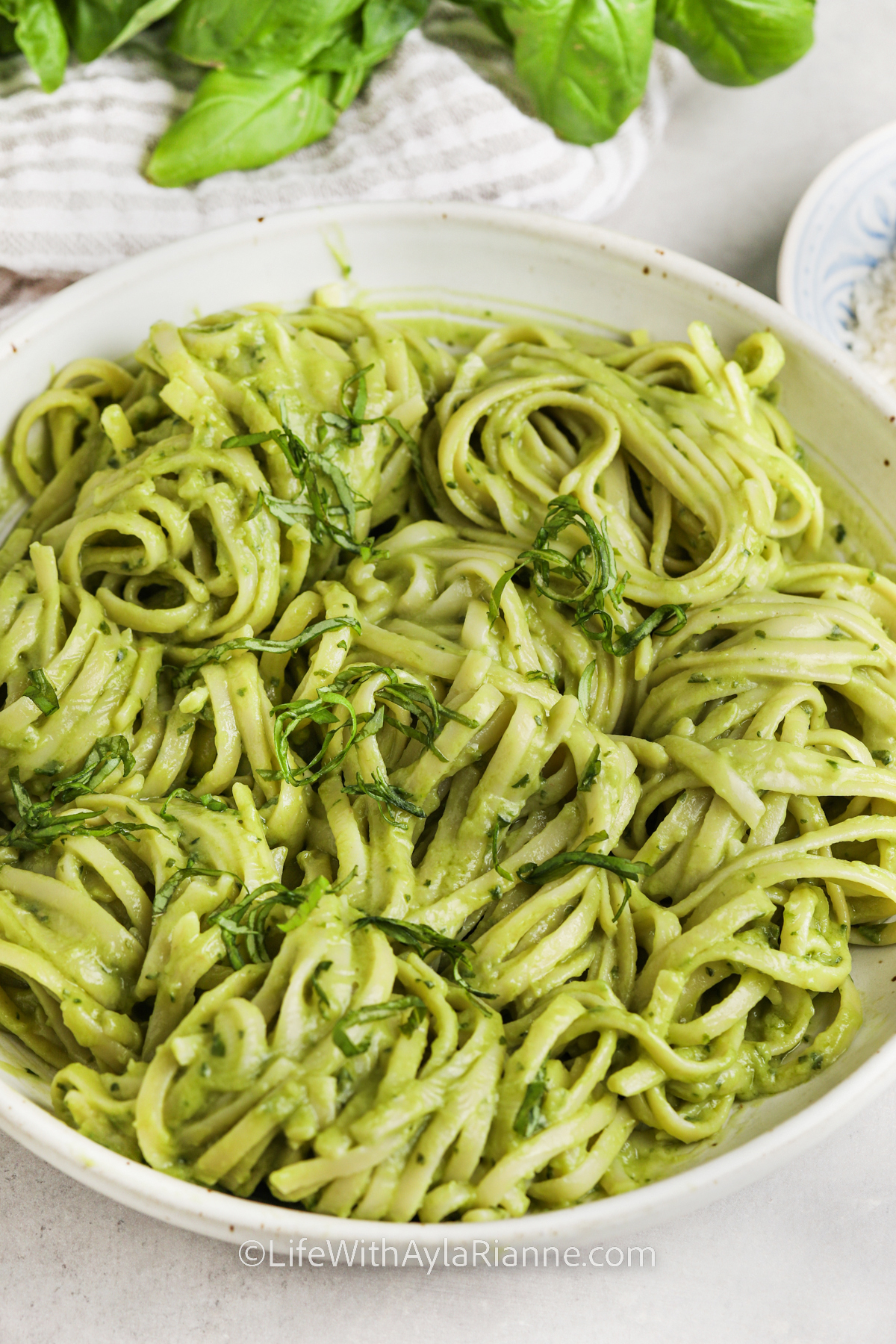 a bowl of avocado pasta topped with basil
