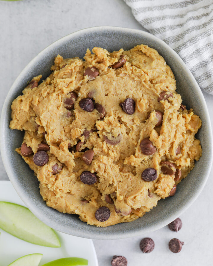 Chickpea Cookie Dough in a bowl with slices of apple on the side