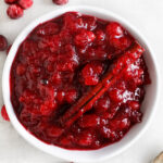 cranberry sauce with orange juice in a white serving bowl with a cinnamon stick