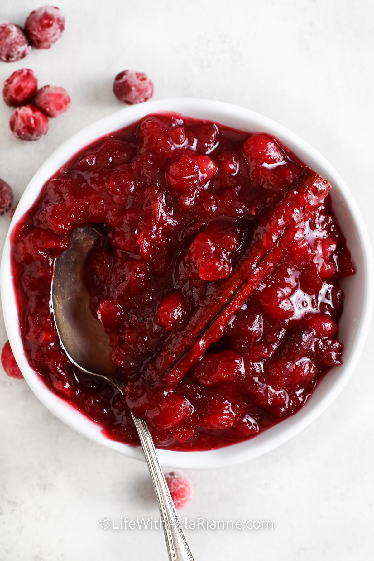 cranberry sauce with orange juice in a white bowl with a spoon
