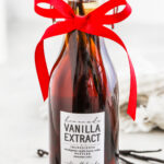 a bottle of homemade vanilla with a label and a bow for how to make vanilla