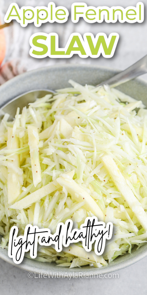 Apple Fennel Slaw in a serving bowl with a spoon and writing