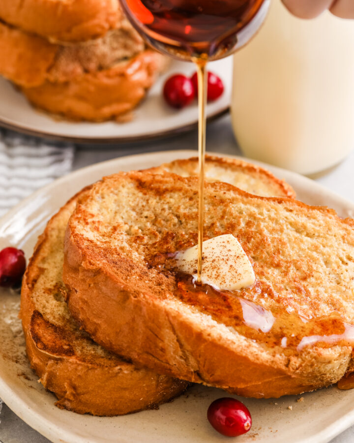 Eggnog French Toast on a plate with syrup being poured on