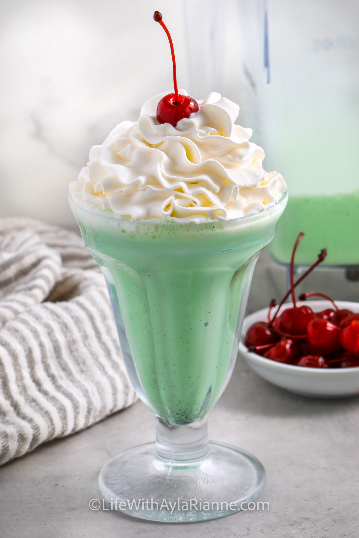 a shamrock shake in a glass with whipped cream on top