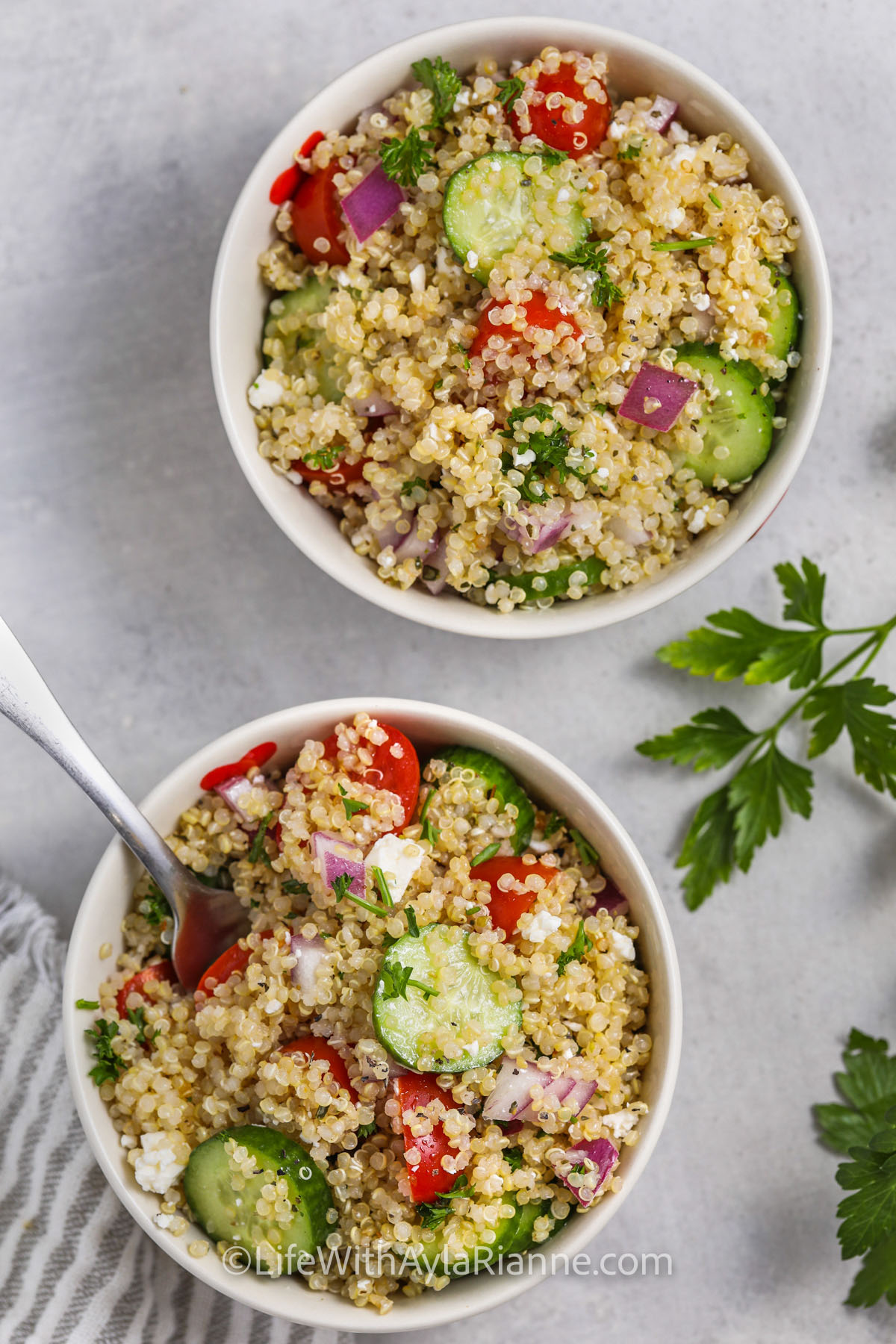 2 bowls of Greek Quinoa Salad, one with a fork