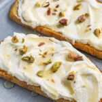 Ricotta Toast on a plate with honey and pistachios