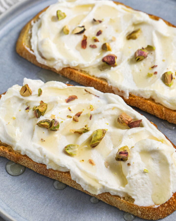 Ricotta Toast on a plate with honey and pistachios
