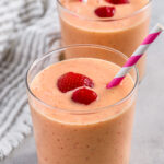 Strawberry Mango Smoothies in a glass with strawberries and straws
