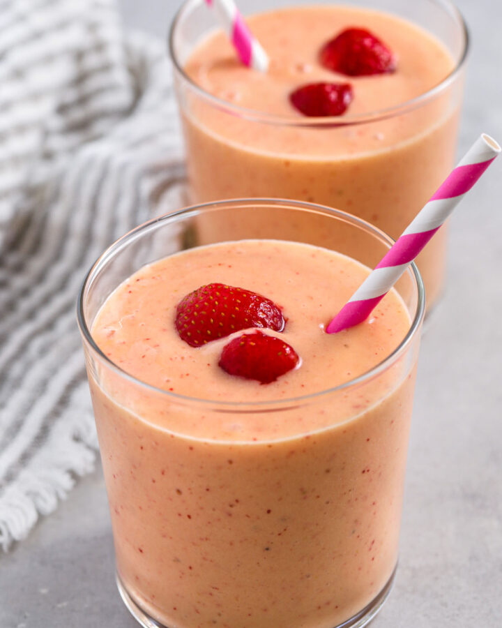 Strawberry Mango Smoothies in a glass with strawberries and straws