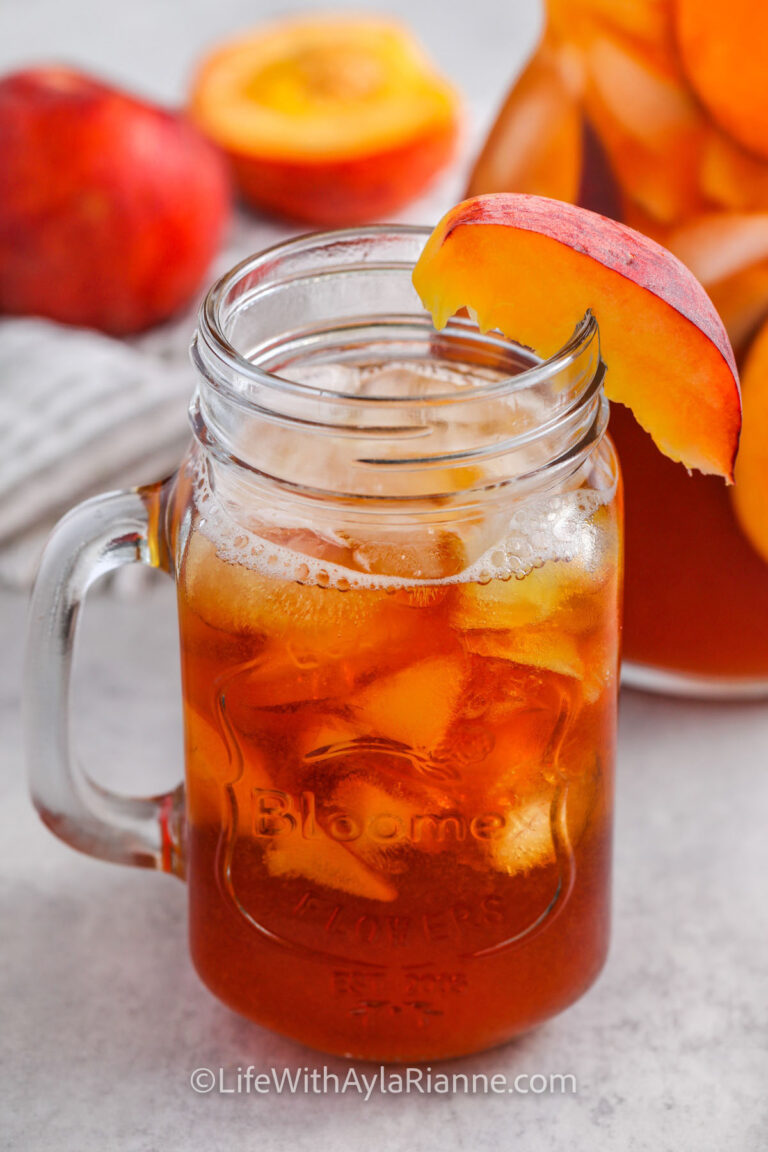 Peach Iced Tea in a glass with a sliced peach on the rim