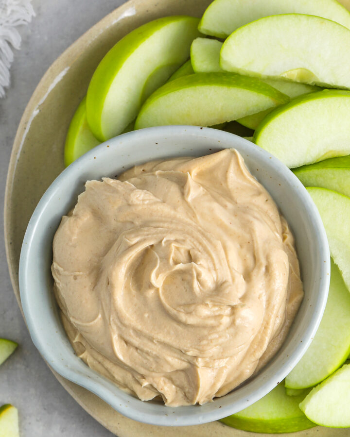 a bowl of peanut butter dip with apples