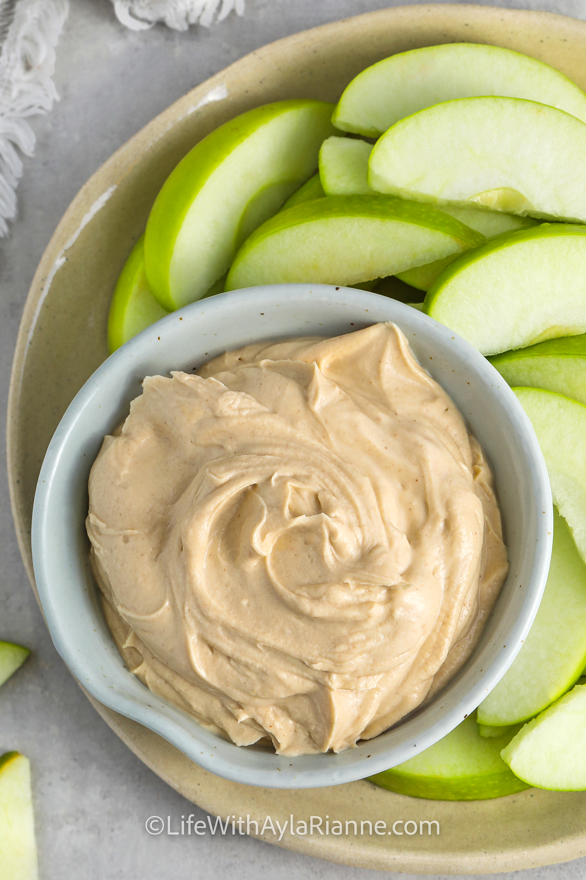 a bowl of peanut butter dip with apples