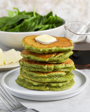 butter on a stack of Spinach Pancakes