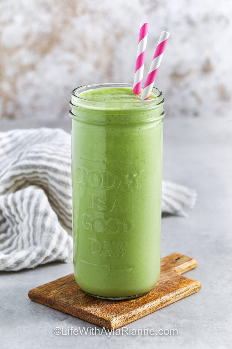 glass of Tropical Green Smoothie with pink striped straws