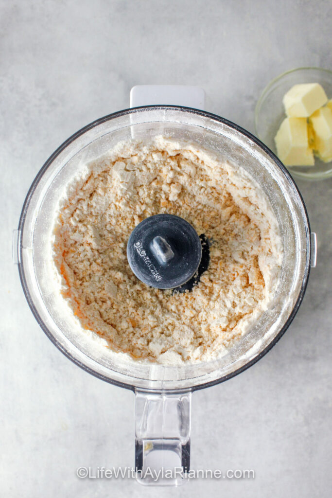 adding ingredients to food processor to make Homemade Cheese Crackers